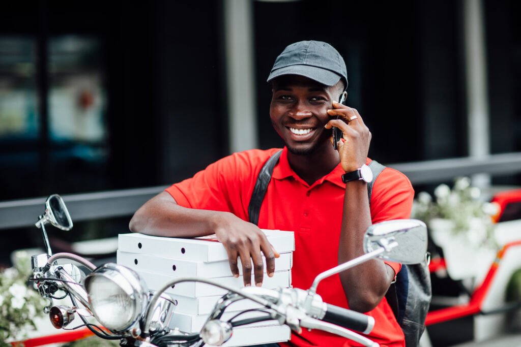 portrait young african guy accepts order by phone motorbike holding boxes with pizza sit his bike urban place Portrait Young African Guy Accepts Order By Phone Motorbike Holding Boxes With Pizza Sit His Bike Urban Place 1024x683